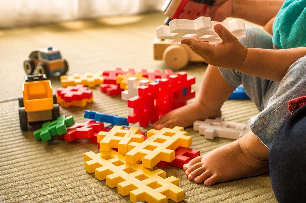 Child playing with building blocks during the babysitting service