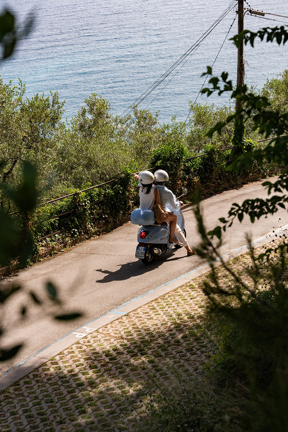 Couple riding a scooter on the panoramic road in Camogli