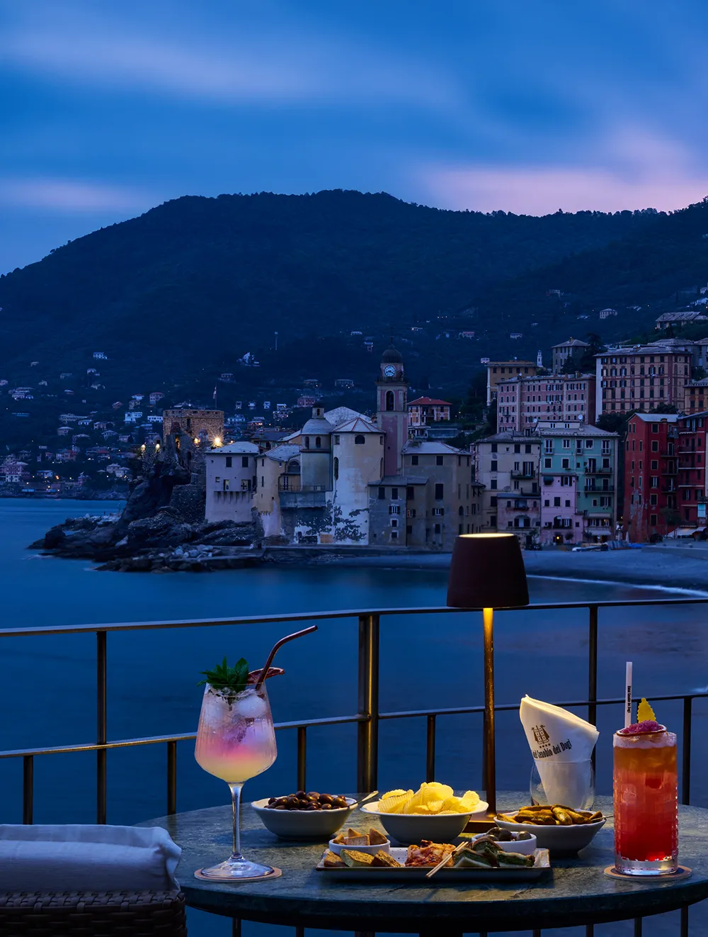 Aperitif on the terrace at sunset overlooking Camogli lit up