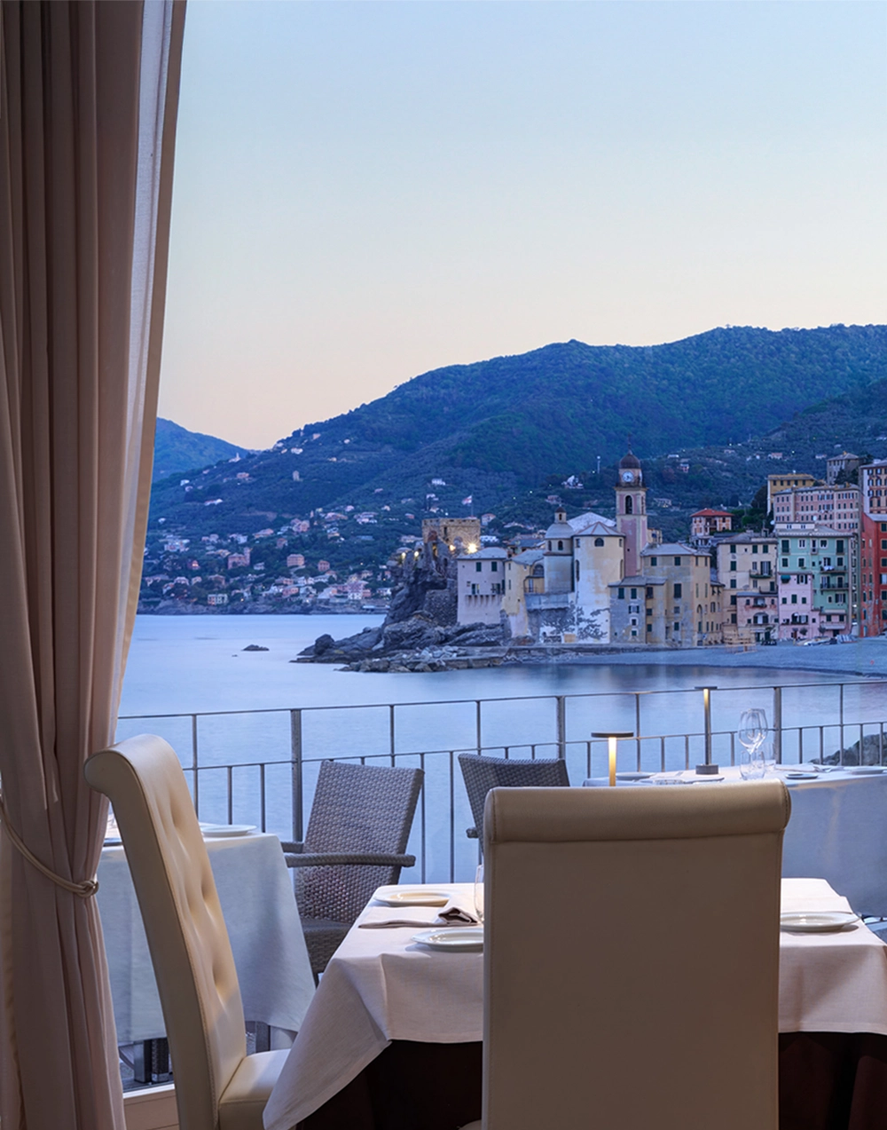 Tavola del ristorante con vista su Camogli al crepuscolo