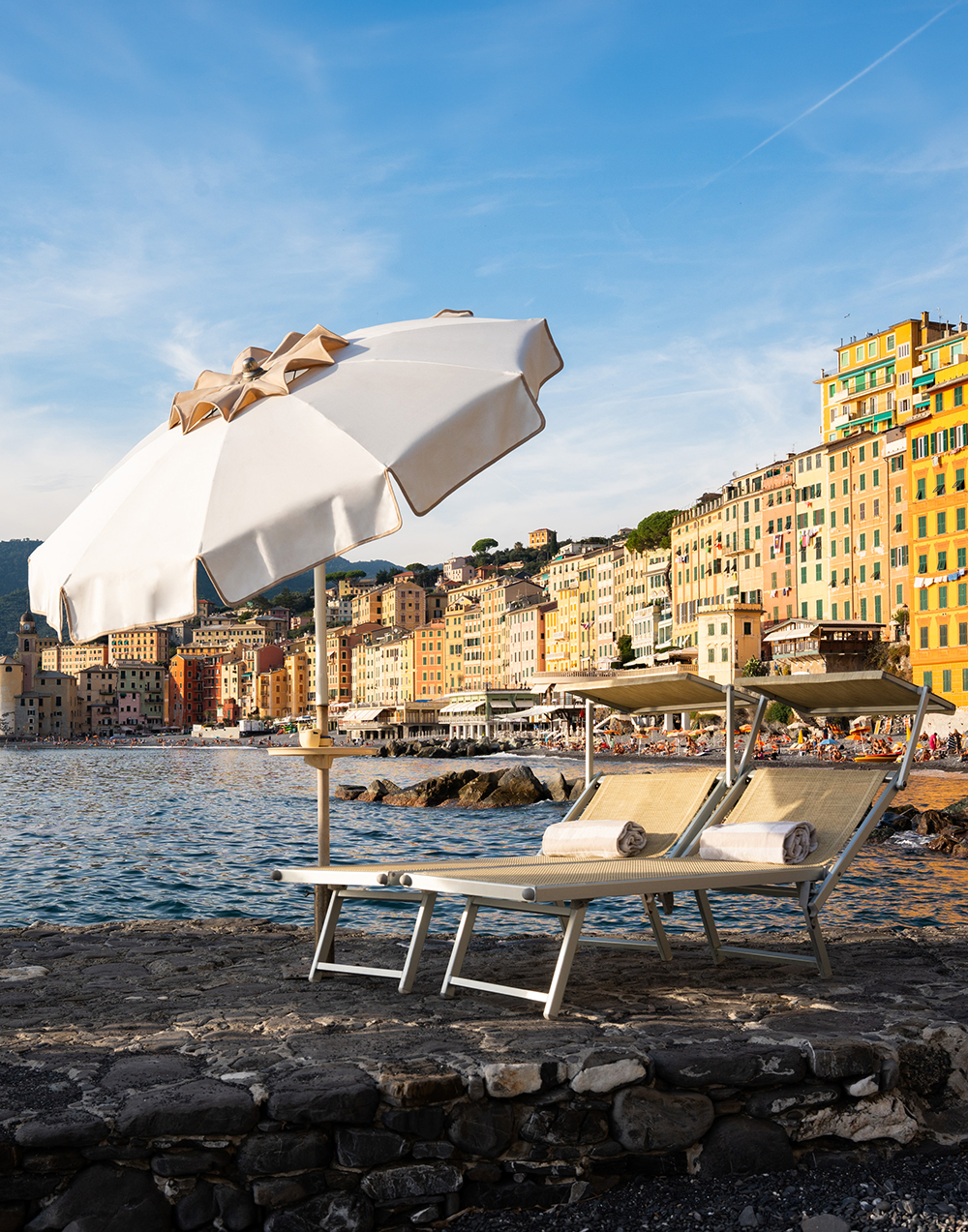 Loungers and umbrella on the hotel beach facing the village of Camogli
